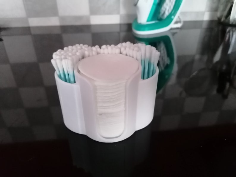 May include: White plastic organizer with two compartments for cotton swabs and a center compartment for cotton rounds. The organizer is filled with cotton swabs and rounds.