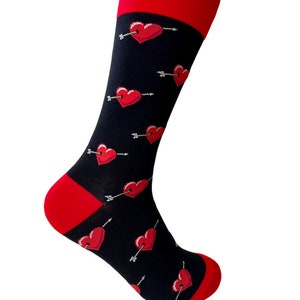 May include: Black socks with a red heart and arrow pattern. The socks have a red cuff.