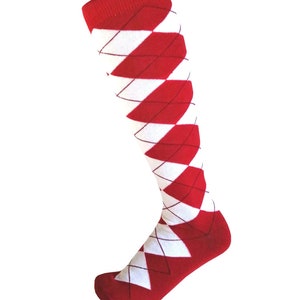 May include: A knee-high sock featuring a classic red and white argyle diamond pattern. The design includes thin dark lines forming the diamond shapes across the fabric, with a solid red cuff at the top and a solid red toe and heel section.