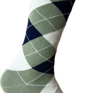 May include: A single green argyle sock with a white, navy, and light green diamond pattern. The sock is made of a ribbed knit material and is angled slightly to the right, showcasing the design.