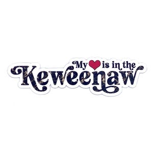 May include: A sticker with the text "My heart is in the Keweenaw." The word "Keweenaw" is in a dark blue font with a marbled pattern. The word "My" and "is in the" are in a dark blue font. A red heart is between "My" and "is".