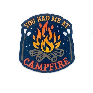May include: A blue and orange sticker with the text "You had me at campfire" and a campfire with flames and marshmallows.