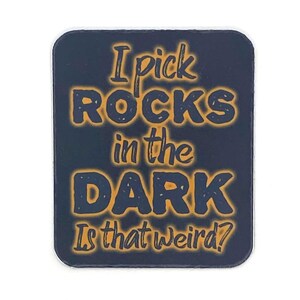 May include: A dark blue square sticker with the text "I pick ROCKS in the DARK Is that weird?" in orange.