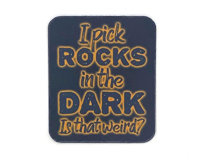 May include: A dark blue square sticker with the text "I pick ROCKS in the DARK Is that weird?" in orange.