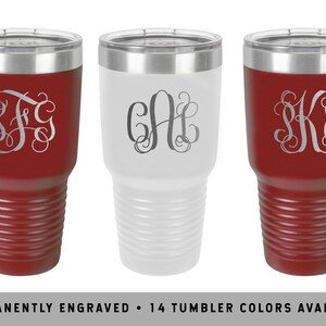May include: Three stainless steel tumblers with different engraved monograms. The tumblers are in red, white, and red colors. The text "PERMANENTLY ENGRAVED - 14 TUMBLER COLORS AVAILABLE" is at the bottom of the image.