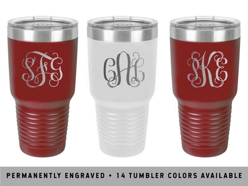 May include: Three stainless steel tumblers with different engraved monograms. The tumblers are in red, white, and red colors. The text "PERMANENTLY ENGRAVED - 14 TUMBLER COLORS AVAILABLE" is at the bottom of the image.