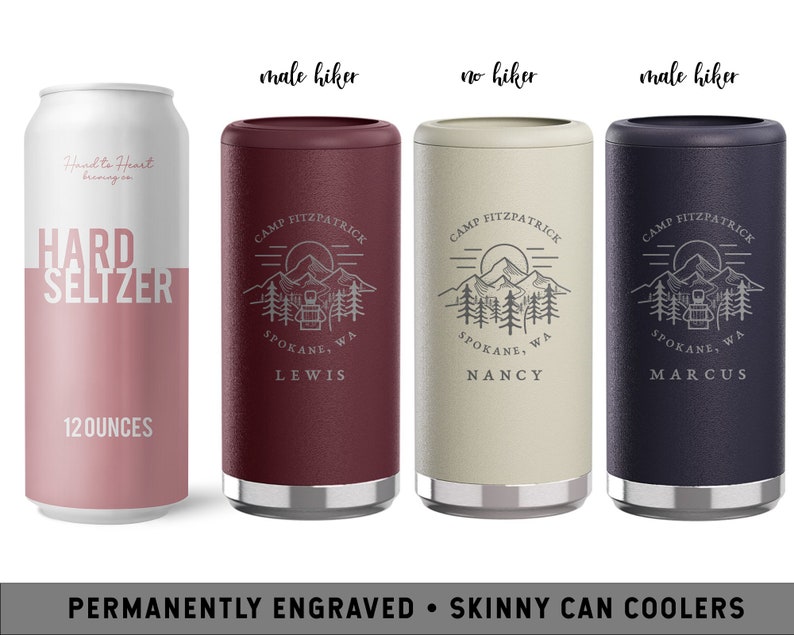May include: Three personalized skinny can coolers with a mountain scene and the text "Camp Fitzpatrick, Spokane, WA". The coolers are in burgundy, beige, and navy blue. The text "Lewis", "Nancy", and "Marcus" are engraved on the coolers.