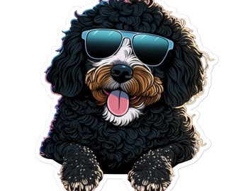 May include: A black and white poodle wearing blue sunglasses with a happy expression. The poodle is peeking out from behind a white surface.