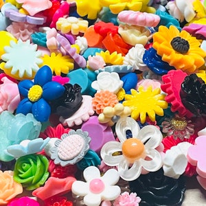 May include: Assortment of colorful resin cabochons in various shapes and sizes, including flowers, stars, and geometric designs. The cabochons are perfect for crafting jewelry, hair accessories, and other decorative projects.