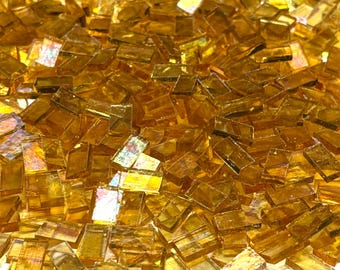 Små skimrande bärnstensfärgade mosaikplattor i färgat glas