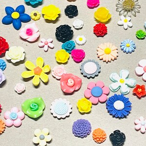 May include: Assortment of colorful flower-shaped resin embellishments in various colors, including pink, blue, yellow, green, and purple. These decorative embellishments are perfect for adding a touch of whimsy to crafts, jewelry, and other projects.
