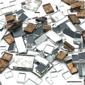 May include: A collection of small, square, and rectangular mirror tiles in various shades of silver, gold, and black. The tiles are arranged in a random pattern and are perfect for crafting projects.