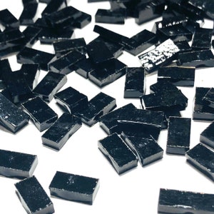 May include: A large quantity of small, black, rectangular tiles. The tiles are glossy and have a smooth surface.