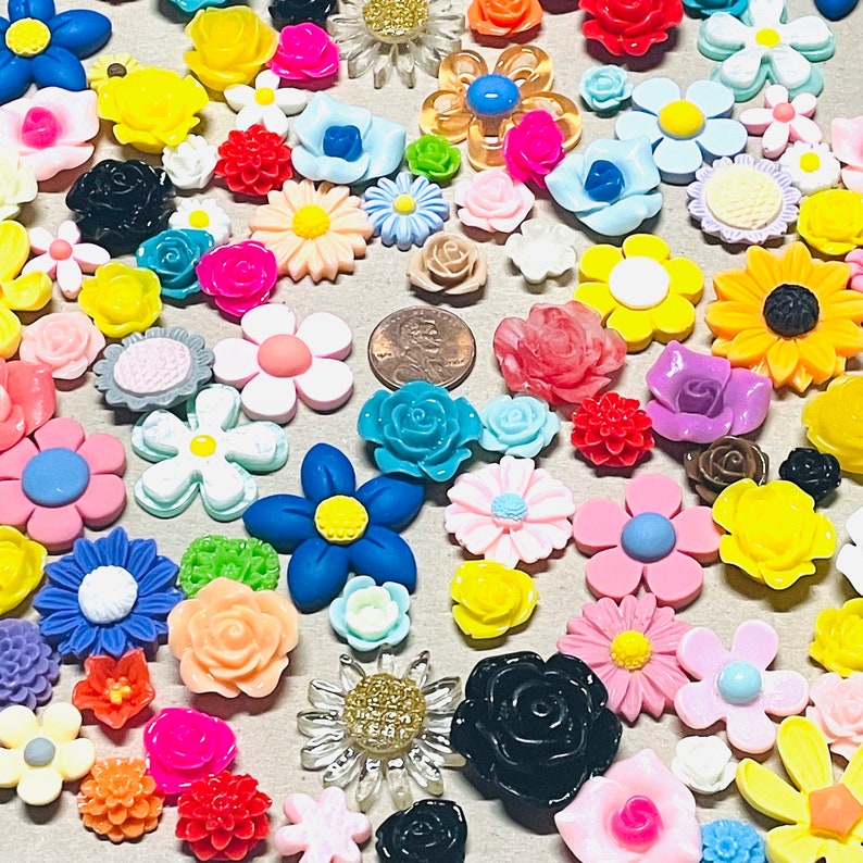 May include: Assortment of colorful flower-shaped resin embellishments in various colors, including pink, blue, yellow, green, red, and white. The embellishments are perfect for crafting and decorating.