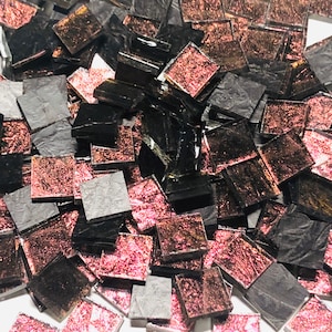 May include: A pile of small, square, iridescent glass tiles in shades of black and burgundy.