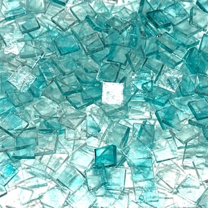 May include: A pile of small, square, turquoise glass tiles. The tiles are translucent and have a slightly iridescent sheen.