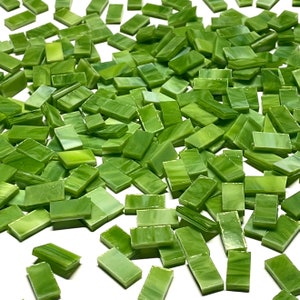 May include: A large quantity of small, green glass tiles. The tiles are rectangular and have a mottled, translucent appearance.