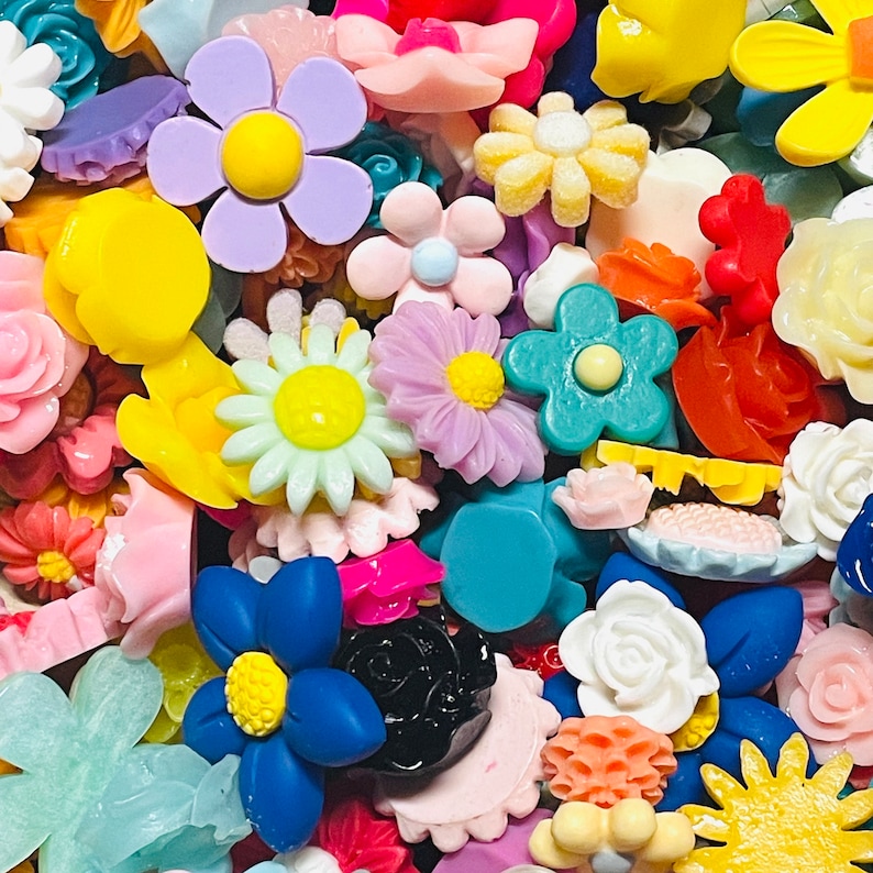 May include: Assortment of colorful resin flower charms in various shapes and sizes. The charms are perfect for adding a touch of whimsy to jewelry, crafts, and other projects.