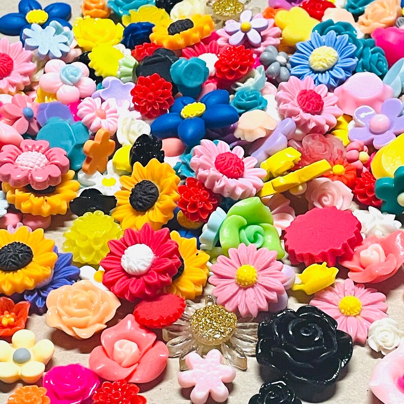 May include: Assortment of colorful flower-shaped resin embellishments in various colors, including pink, blue, yellow, green, red, and black. The embellishments are perfect for crafting and decorating.