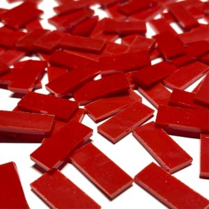 Könnte beinhalten: Eine große Menge kleiner, rechteckiger roter Glasfliesen. Die Fliesen sind glänzend und haben einen leichten Schimmer.