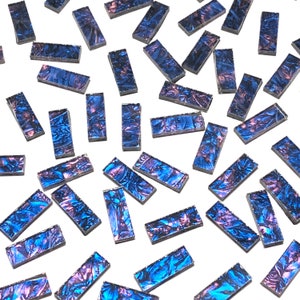 May include: A collection of iridescent blue and purple glass tiles in a rectangular shape. The tiles have a metallic sheen and are scattered on a white background.