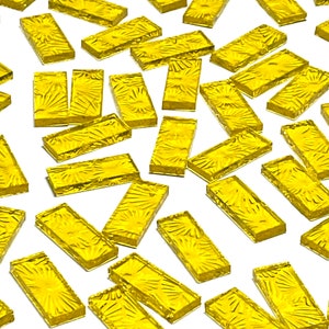 Op de afbeelding: Een verzameling gele glazen tegels met een getextureerd, zonnestralenontwerp. De tegels zijn rechthoekig en hebben een glanzende afwerking.