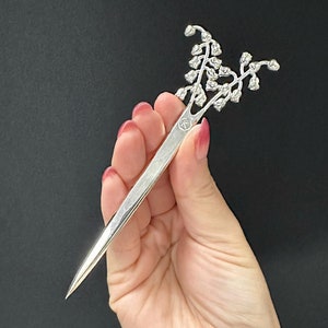 Abrecartas con la flor de nacimiento de mayo (lirio de los valles)