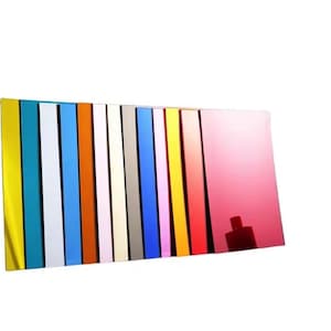 May include: A collection of colorful, rectangular acrylic sheets in various shades, including yellow, blue, white, pink, and red. The sheets are arranged vertically, creating a vibrant display of color and texture. The reflective surfaces catch the light.