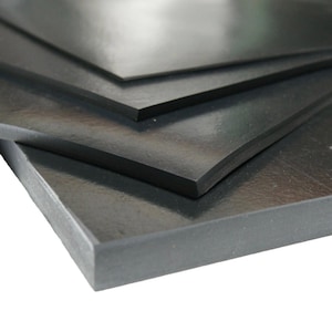 May include: A stack of multiple rectangular black rubber sheets with a smooth, matte finish. The sheets are layered on top of each other, showing their thickness and flat, uniform surfaces. Each sheet has sharp, clean edges and a consistent dark color.
