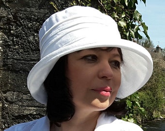 Classic linen sun hat in four colours for women. Stiffened brim, packs and travels well. Denim, white, cream and stone. Two adjustable sizes