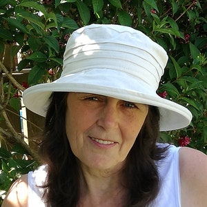 Klassischer cremefarbener Sonnenhut aus Leinen für Damen mit versteifter Krempe, packt und reist gut.
