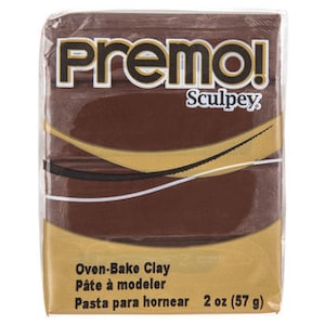 May include: A 2 ounce (57 gram) block of Premo! Sculpey oven-bake clay in a brown color. The packaging features the brand name and the words "Oven-Bake Clay", "Pâte à modeler", and "Pasta para hornear".