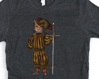 May include: A dark heather grey t-shirt with a cartoon illustration of a cat wearing a jester's hat and holding a sword. The cat is wearing a yellow and red striped outfit.