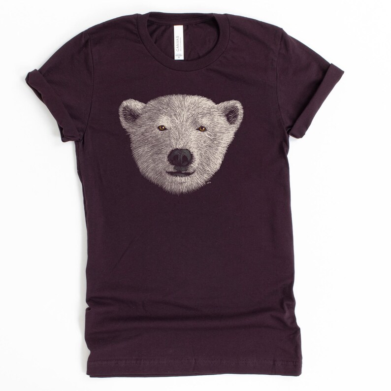 May include: A dark purple t-shirt featuring a white polar bear face graphic.