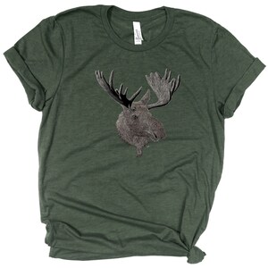 May include: A dark green t-shirt with a white outline drawing of a moose head on the front.
