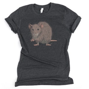 Pode incluir: Uma camiseta cinza escura mesclada com uma ilustra&ccedil;&atilde;o realista de um rato marrom. O rato est&aacute; em p&eacute; sobre suas quatro patas e tem uma express&atilde;o ligeiramente surpresa.