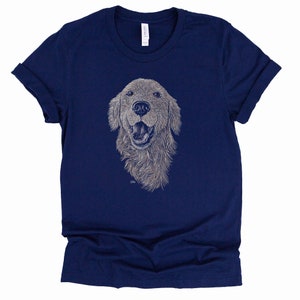 May include: A navy blue t-shirt with a white line drawing of a golden retriever dog's head. The dog is smiling with its tongue out.