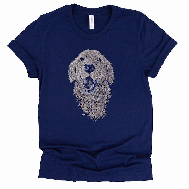 May include: A navy blue t-shirt with a white line drawing of a golden retriever dog's head. The dog is smiling with its tongue out.