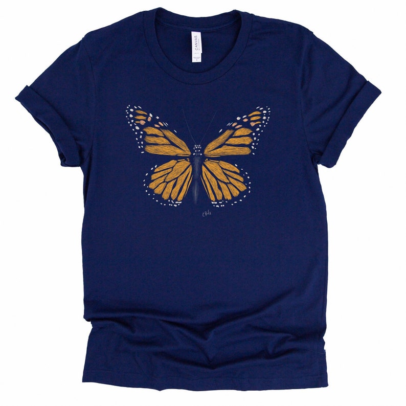 May include: A navy blue t-shirt with a graphic of a monarch butterfly in shades of orange and yellow.
