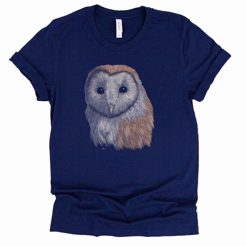 K&ouml;nnte beinhalten: Ein marineblaues T-Shirt mit einer Illustration einer wei&szlig;en und braunen Scheune Eule auf der Vorderseite.