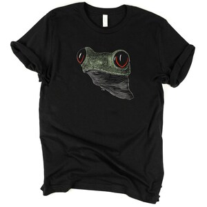May include: Black t-shirt with a green and white line drawing of a frog's face with red eyes.