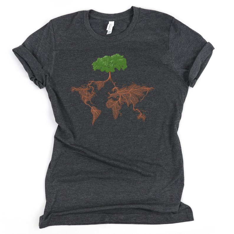 Puede incluir: Una camiseta gris oscuro con un &aacute;rbol verde cuyas ra&iacute;ces marrones forman la forma del mundo.