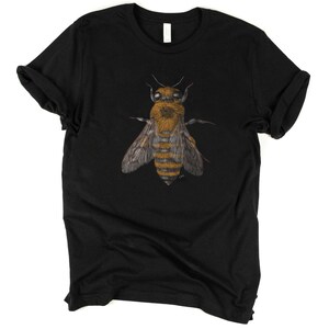 Może przedstawiać: Czarny T-shirt z szczeg&oacute;łową ilustracją pszczoły w odcieniach brązu i ż&oacute;łci.