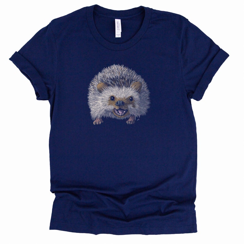Peut inclure: Un t-shirt bleu marine avec un imprim&eacute; d'un h&eacute;risson avec un sourire narquois.