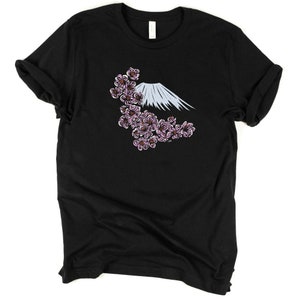 May include: Black t-shirt with a white and blue mountain and pink cherry blossoms graphic.