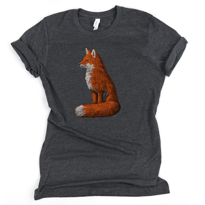 May include: A dark heather grey t-shirt featuring a graphic of a red fox sitting with its tail curled around its body.