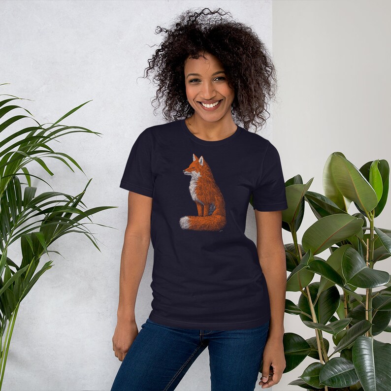 May include: A navy blue t-shirt featuring a graphic of a red fox sitting with its tail curled around its body.