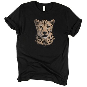 May include: Black t-shirt with a cheetah face graphic printed on the front. The cheetah has a tan and black spotted coat and yellow eyes.