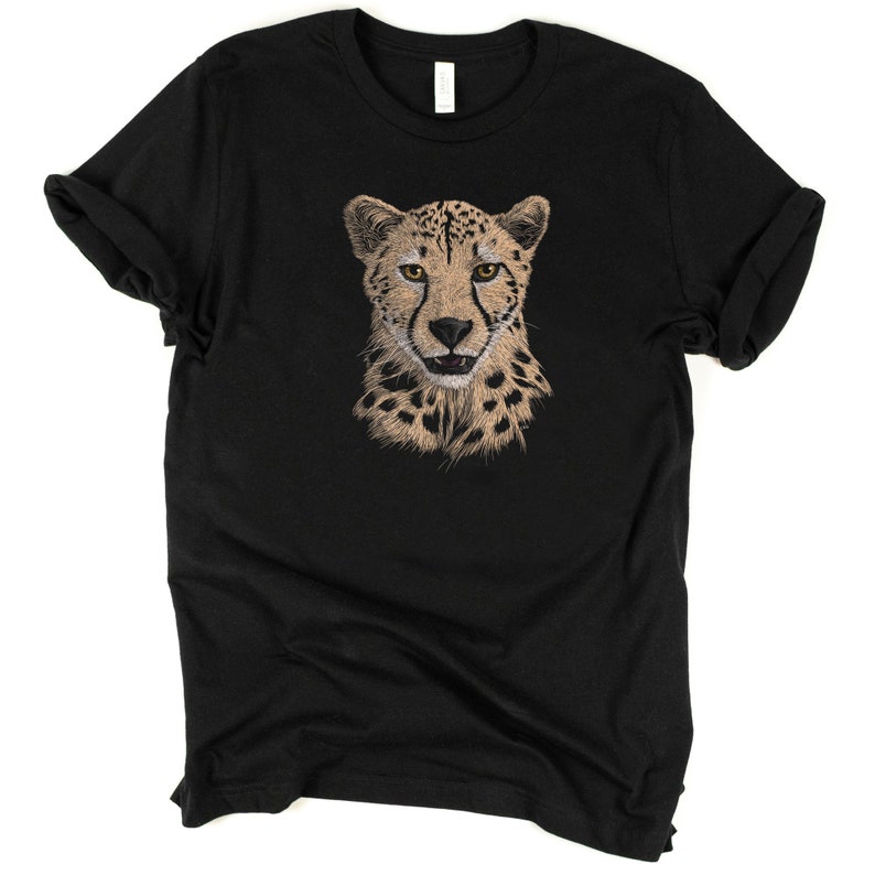 May include: Black t-shirt with a cheetah face graphic printed on the front. The cheetah has a tan and black spotted coat and yellow eyes.