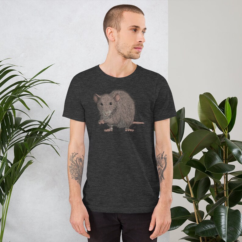 Pode incluir: Uma camiseta cinza escura com uma ilustra&ccedil;&atilde;o de desenho animado de um rato marrom. O rato est&aacute; sentado em suas patas traseiras e segurando um peda&ccedil;o de comida em suas patas.
